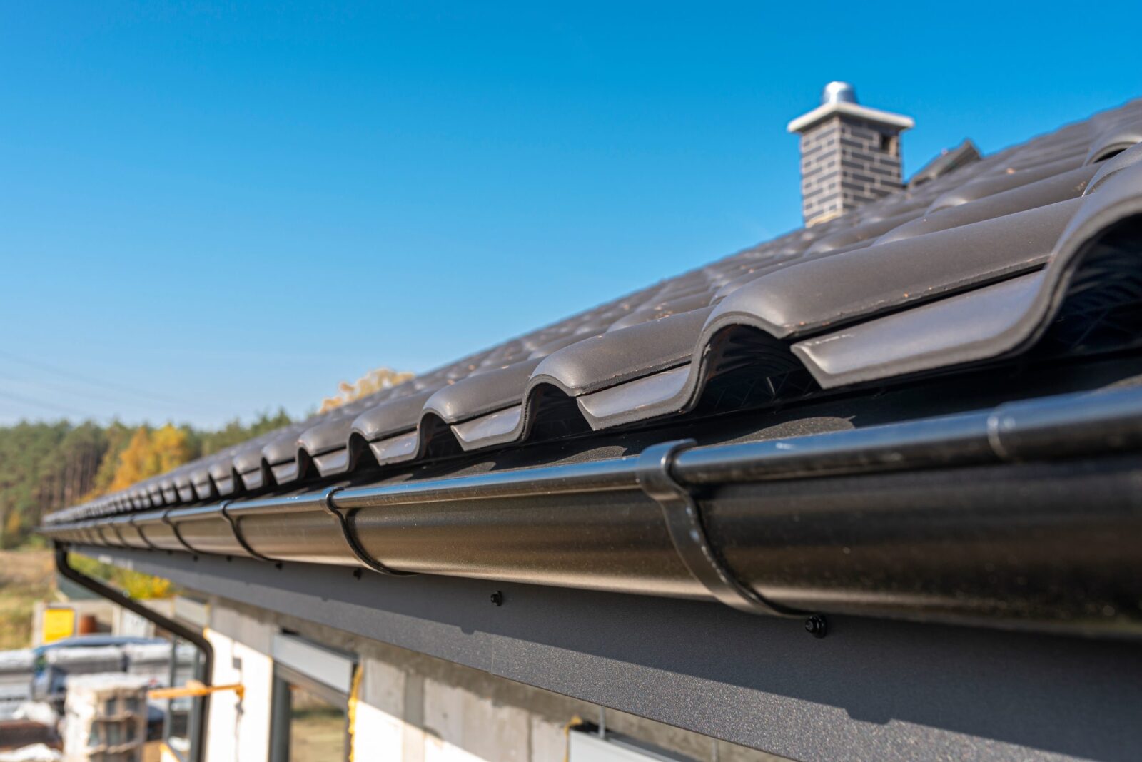 Metal Black Guttering on a roof with UPVC and Ceramic Roof Tiles