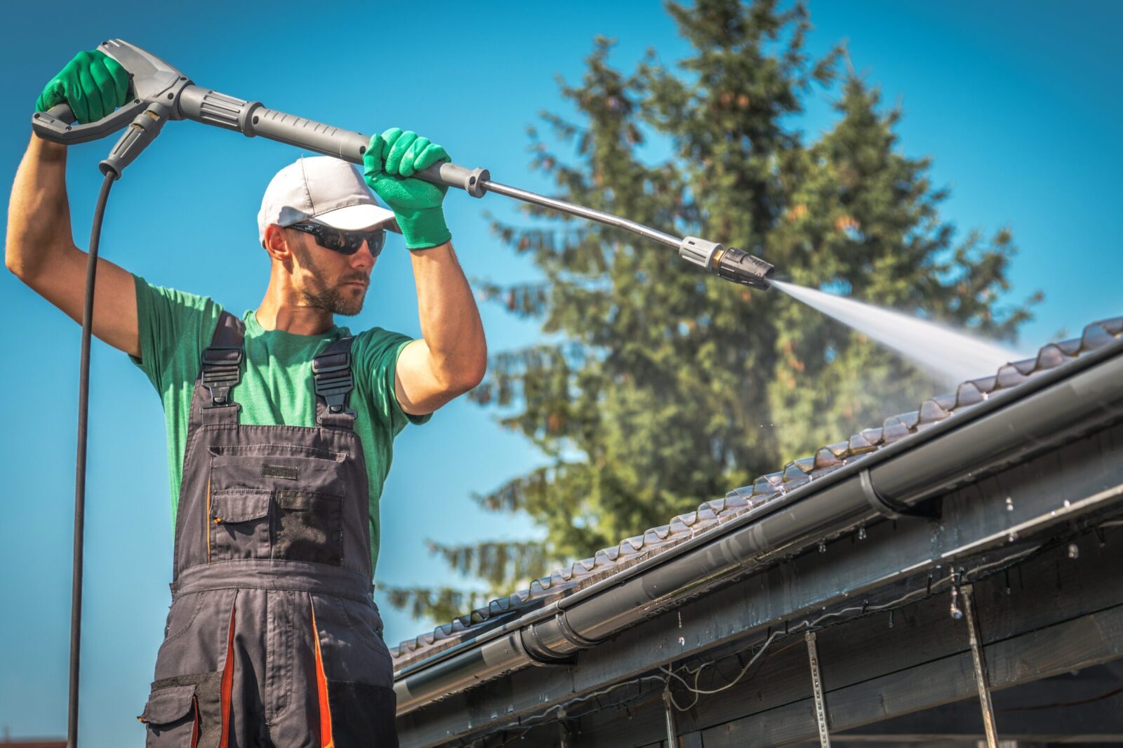 Man using a jet wash to clean roof