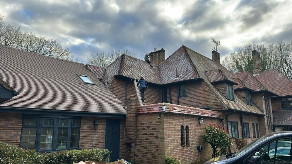 Seasonal Property Maintenance - man on a ladder inspecting the guttering
