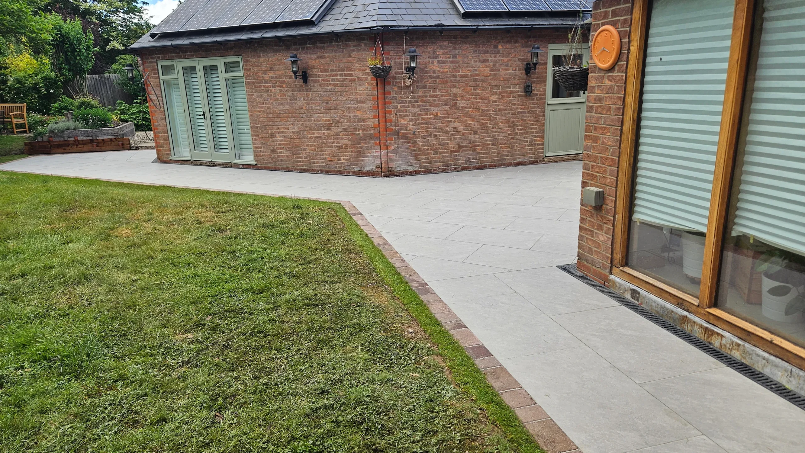 Premium Porcelain Patio with Brick Border and Professional Landscaping